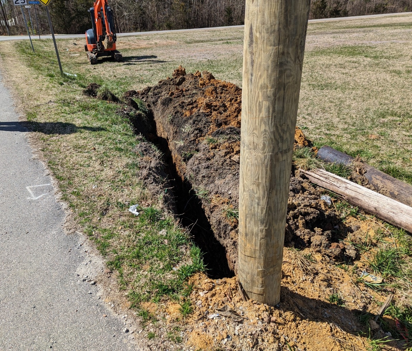 Roadside trench excavation near a utility pole